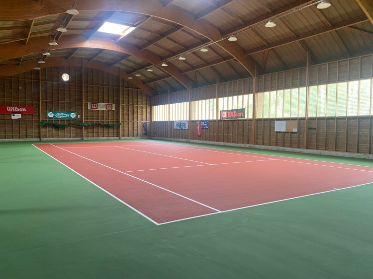 Construction d’un court de tennis en résine par ADN-SOL, offrant une surface durable et uniforme, idéale pour un jeu rapide.