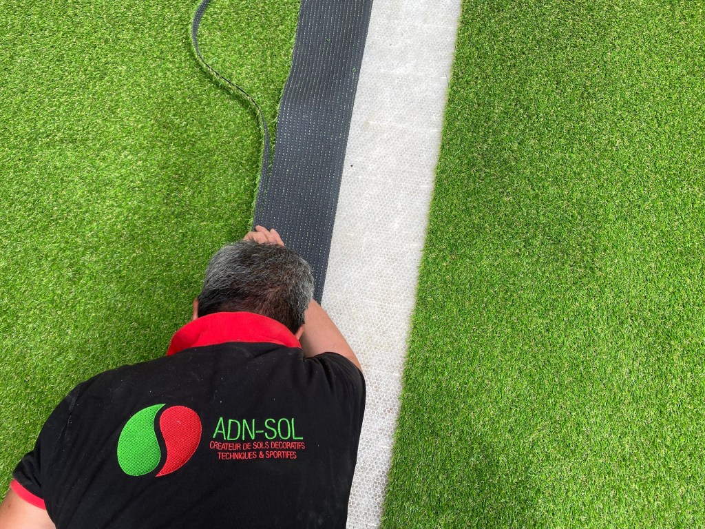 Construction d'un court de tennis en gazon synthétique à Paris par ADN-SOL.