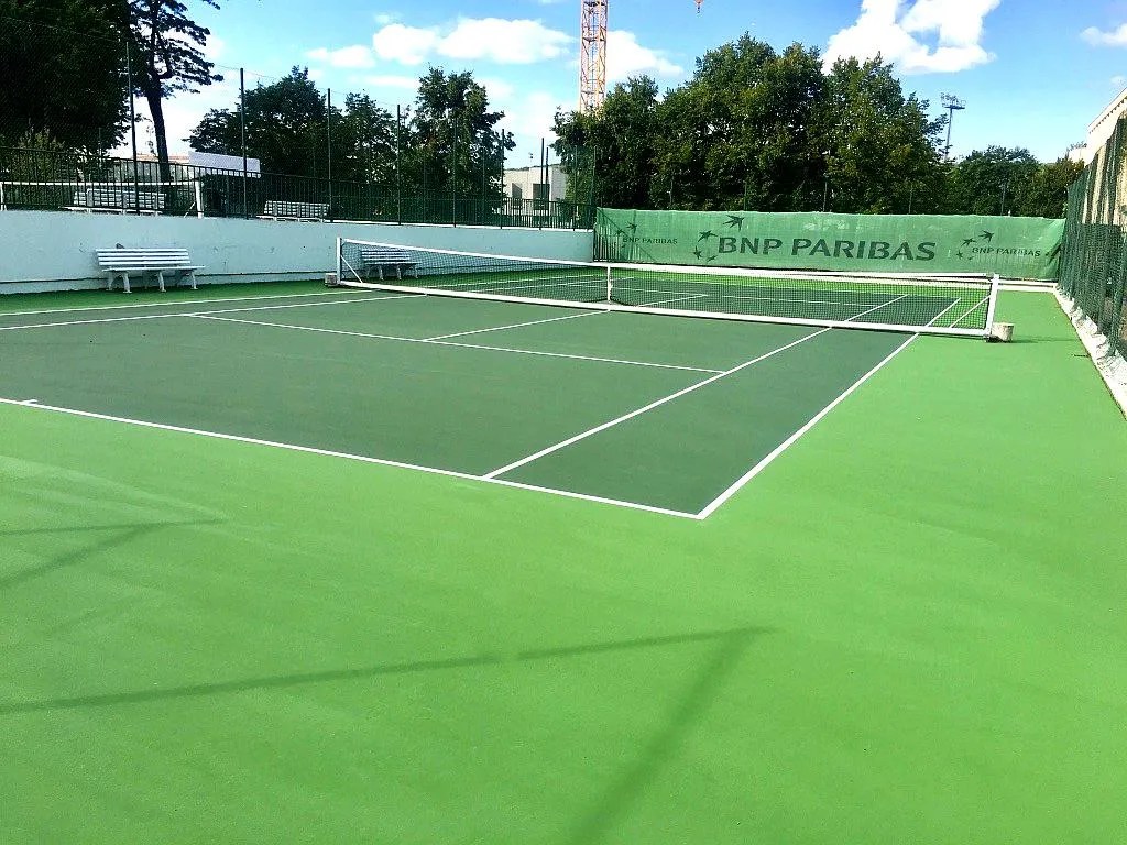 Court de tennis extérieur en résine synthétique construit par ADN-SOL, constructeur de terrains de tennis en France.