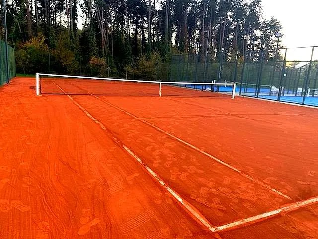 Court de tennis intérieur en terre battue réalisé par ADN-SOL, expert en construction de terrains de tennis.