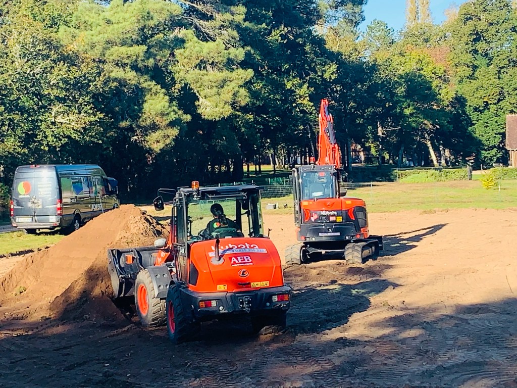 Opérateurs ADN SOL réalisant le terrassement d’un court de tennis avec pelle mécanique et chargeuse – préparation conforme aux normes NF P90-110