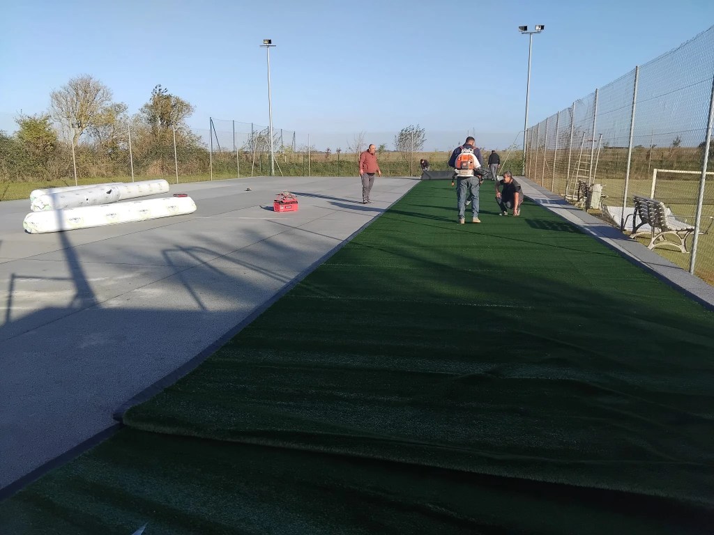 Construction d’un court de tennis en gazon synthétique sur béton poreux avec préparation et pose par ADN SOL"